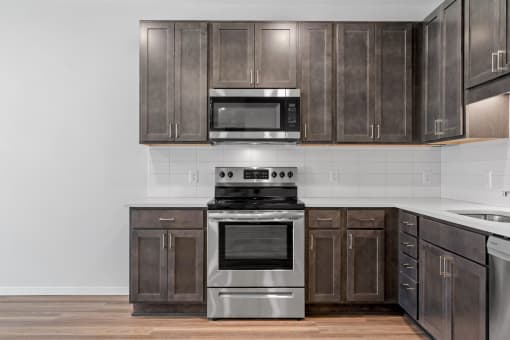 a kitchen with stainless steel appliances and dark wood cabinets
