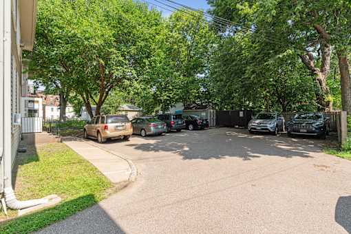 a parking lot with cars parked in front of a house