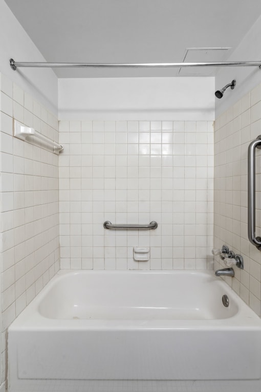 a white tub in a bathroom with white tiles