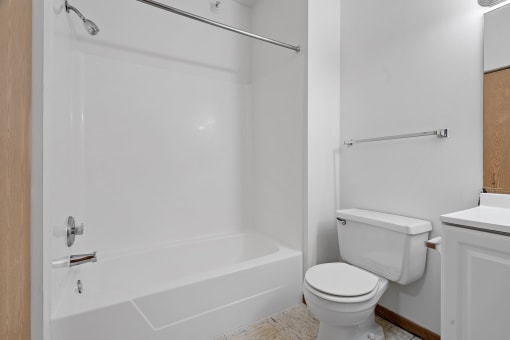 a bathroom with a toilet and a tub and a sink