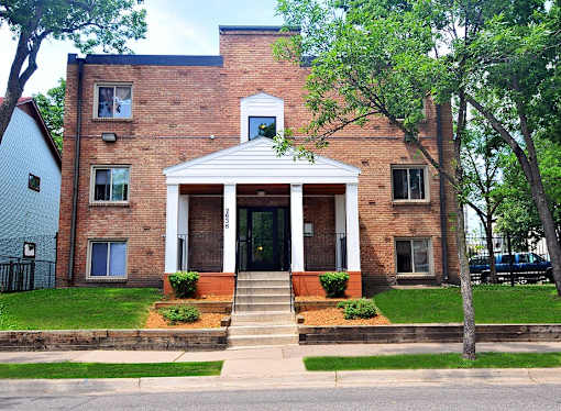 A brick house with a white front porch and steps.