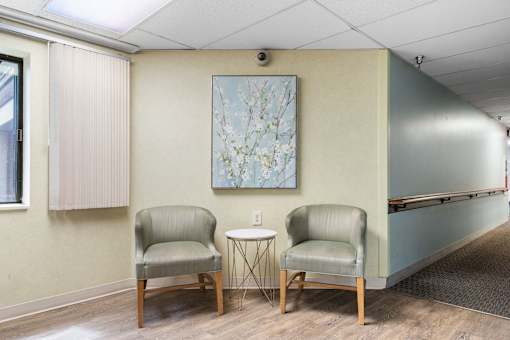 two chairs in a room with a table and a painting on the wall