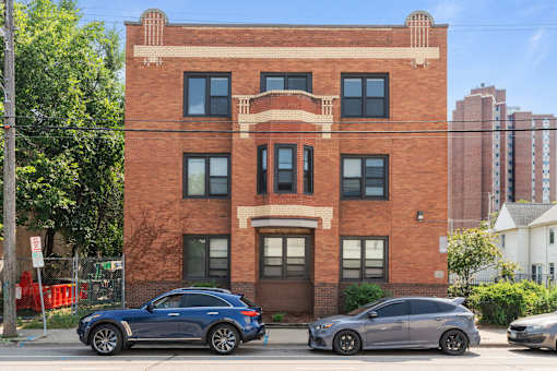 a brick building with cars parked in front of it