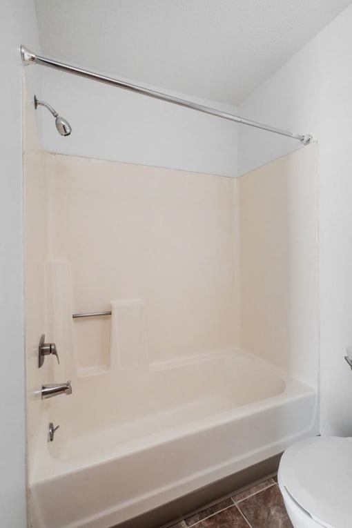 a white bathroom with a tub and a toilet