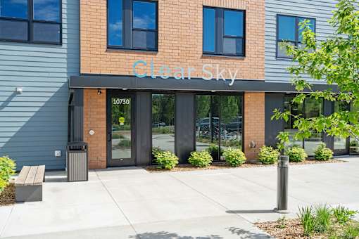 Clear Sky building with a bench in front.