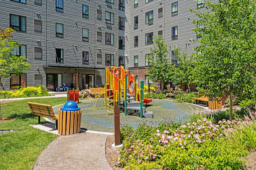 a playground in a park with benches and a fire hydrant
