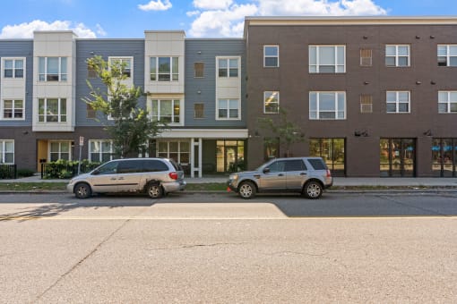 two cars parked in front of an apartment building