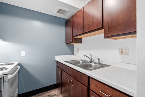 a kitchen with wooden cabinets and a sink and a stove