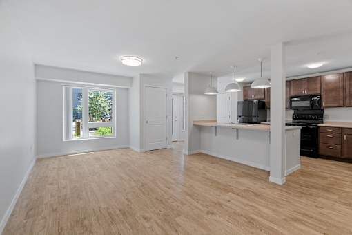 an empty kitchen and living room with a large window