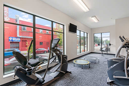 a gym with exercise equipment and large windows