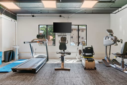 a fitness room with treadmills and other exercise equipment