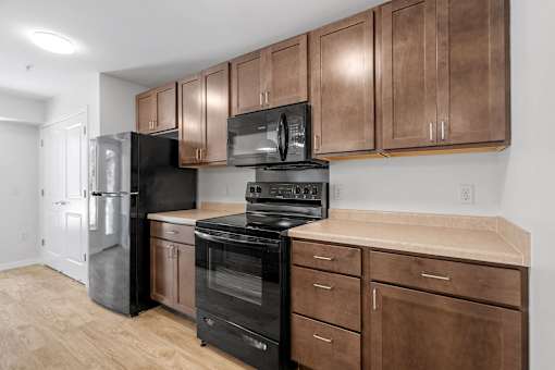 a kitchen with black appliances and wooden cabinets
