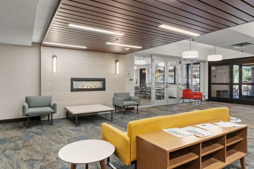 a lounge area with chairs and tables and a fireplace