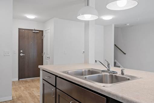 a kitchen with a sink and a door to a hallway