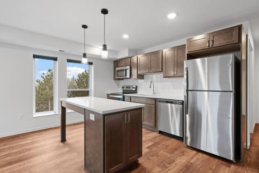 An apartment kitchen with stainless steel appliances and an island.