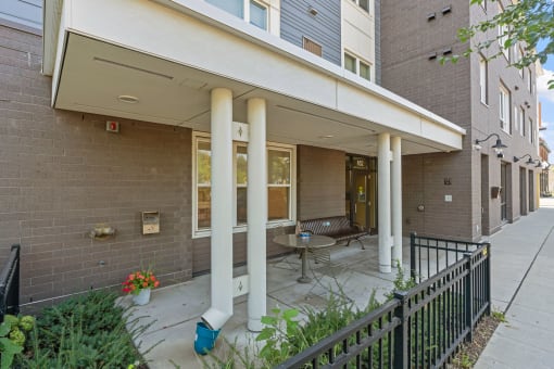 a patio with a table and chairs in front of a brick building