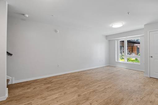 a living room with white walls and a window
