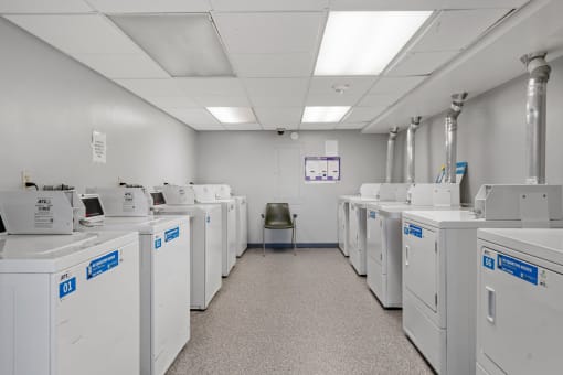 a room filled with washers and dryers and a chair
