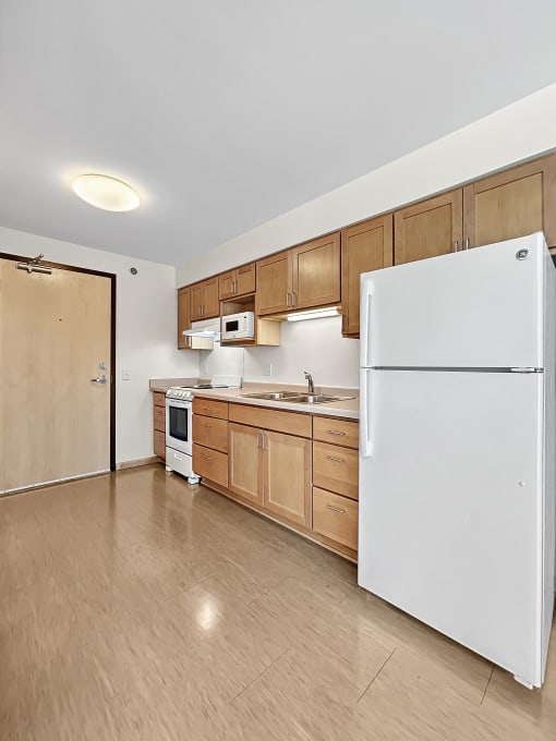 a kitchen with wooden cabinets and a white refrigerator