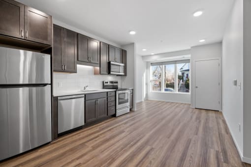 a kitchen with stainless steel appliances and wooden floors