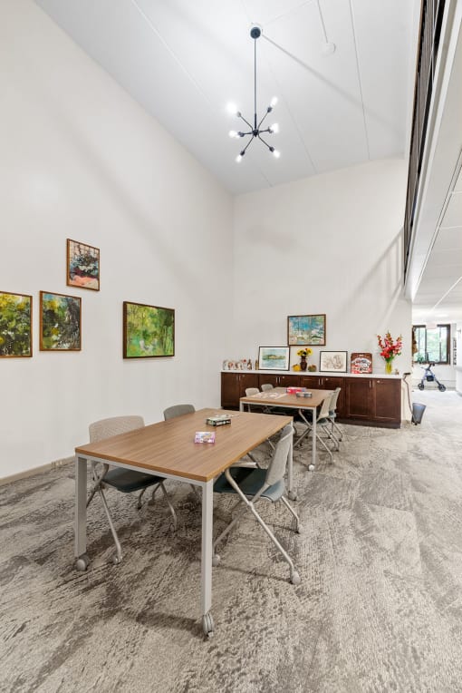 a conference room with a table and chairs and paintings on the wall