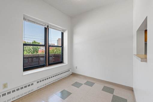 a living room with a large window and a tiled floor