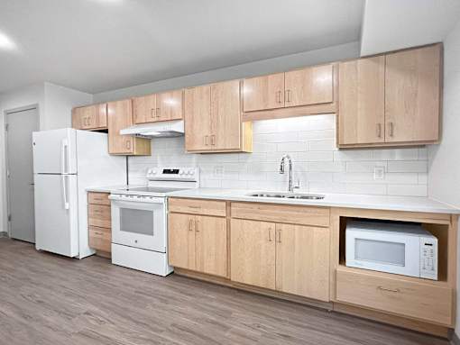 a kitchen with white appliances and wooden cabinets