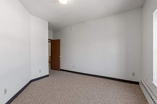 an empty room with white walls and a door to a bathroom