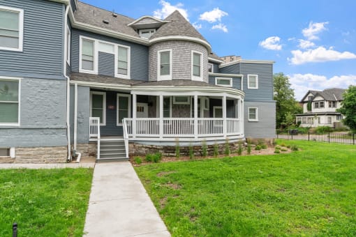 a house covered in striped umbrellas and a lawn with grass