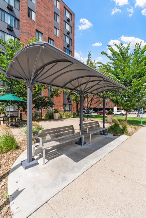 a park with benches and awnings on a sidewalk