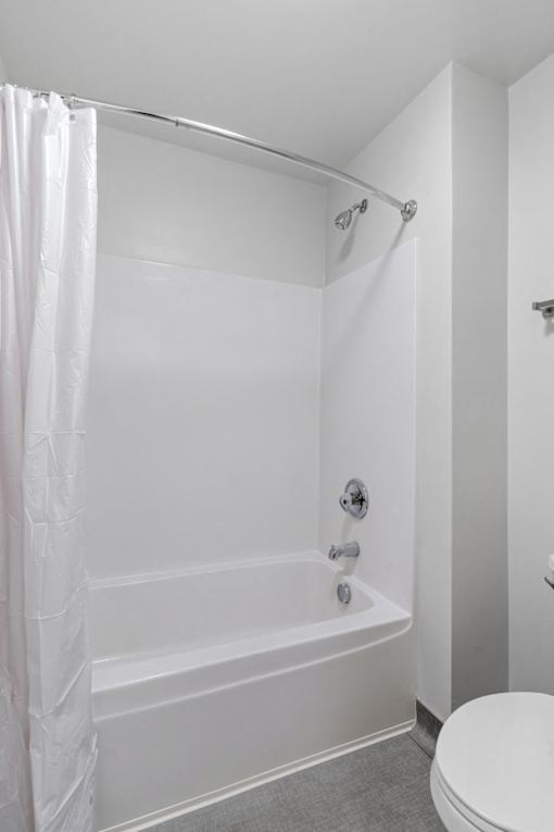 a white bathroom with a shower and a toilet