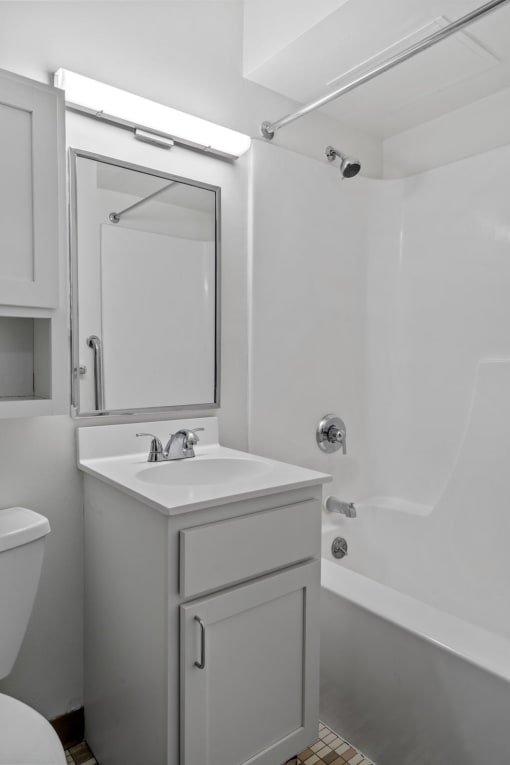 a white bathroom with a sink and a mirror