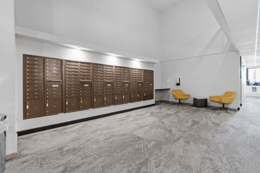 a large locker room in a building with yellow chairs