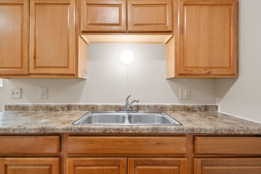 a kitchen with wood cabinets and granite counter tops and a sink