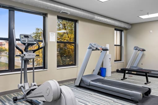 two treadmills and other exercise equipment in a gym