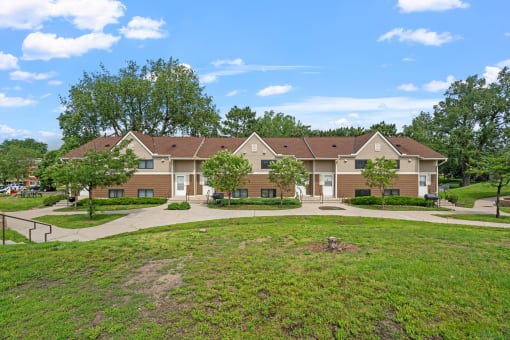 a group of houses in a neighborhood with green grass and trees