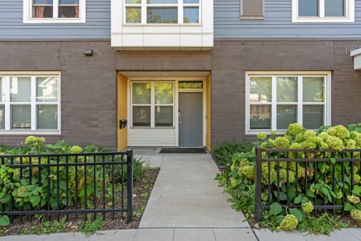 the front of a brick house with a sidewalk in front