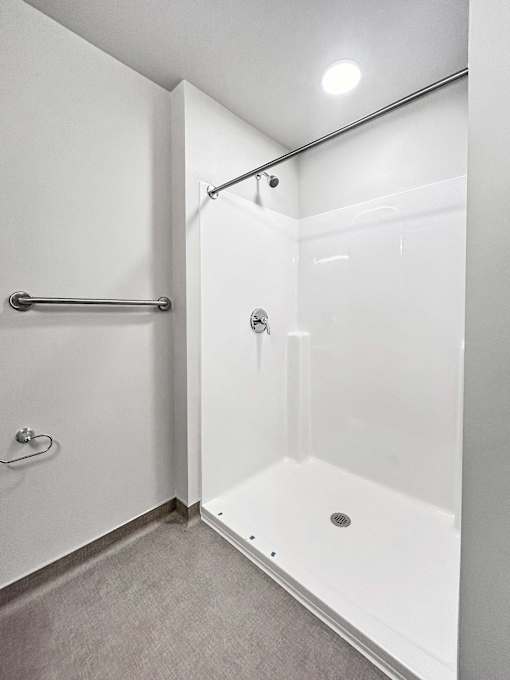 a white shower with a sliding glass door in a bathroom