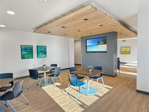 A conference room with a TV screen and chairs.