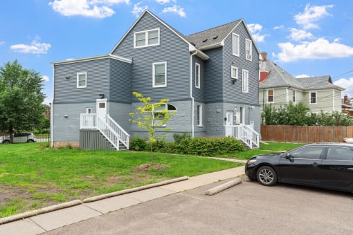 a blue house with a black car parked in front of it