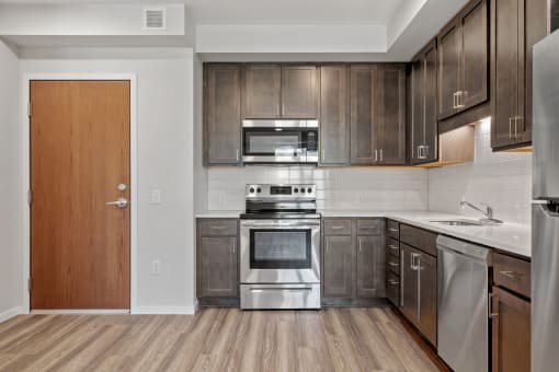 a kitchen with wooden cabinets and stainless steel appliances