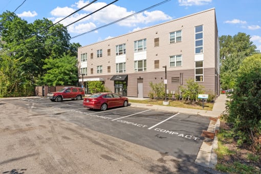 an apartment building with two cars parked in front of it