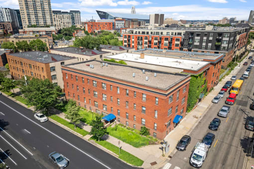 an aerial view of an old brick building with a white roof on a city street