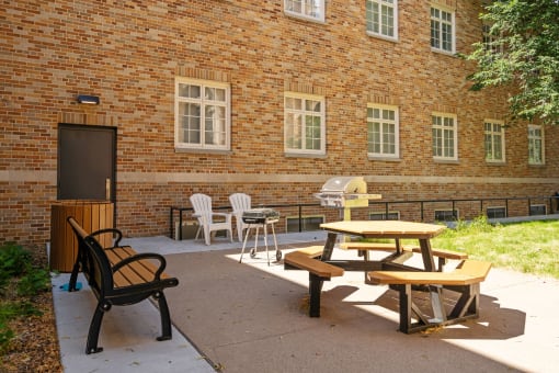 a patio outside of a brick building with tables and chairs