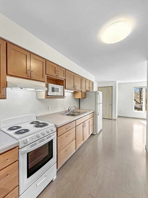 a kitchen with white appliances and wooden cabinets