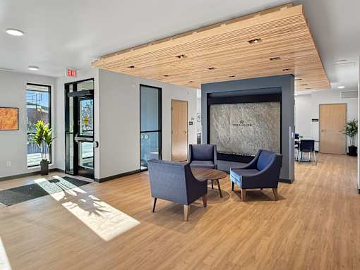 A modern office lobby with wooden floors and furniture.