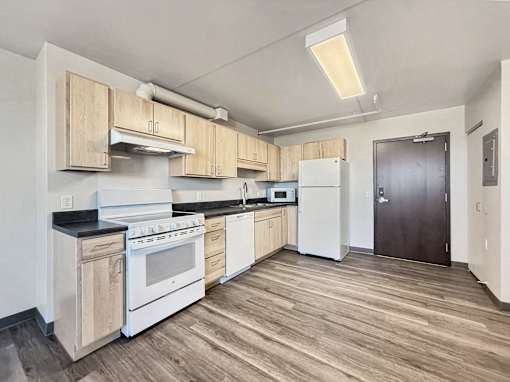 A kitchen with white appliances and wooden cabinets.