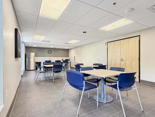 A conference room with a white table and blue chairs.