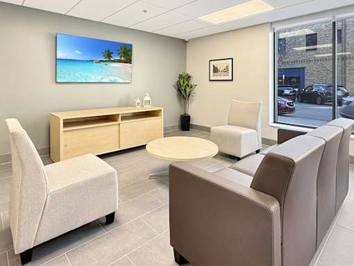 A waiting room with a flat screen TV mounted on the wall.