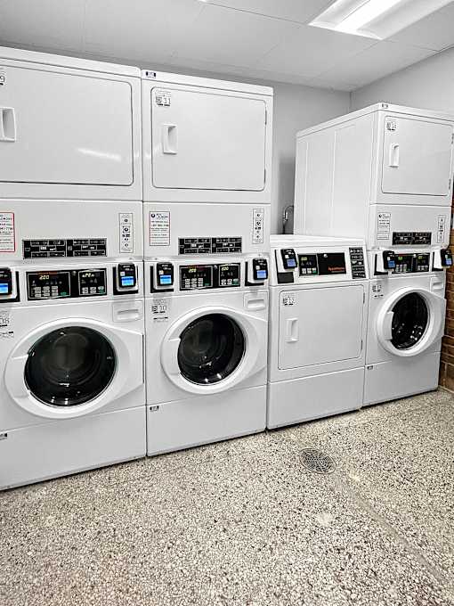 a row of washers and dryers in a laundry room